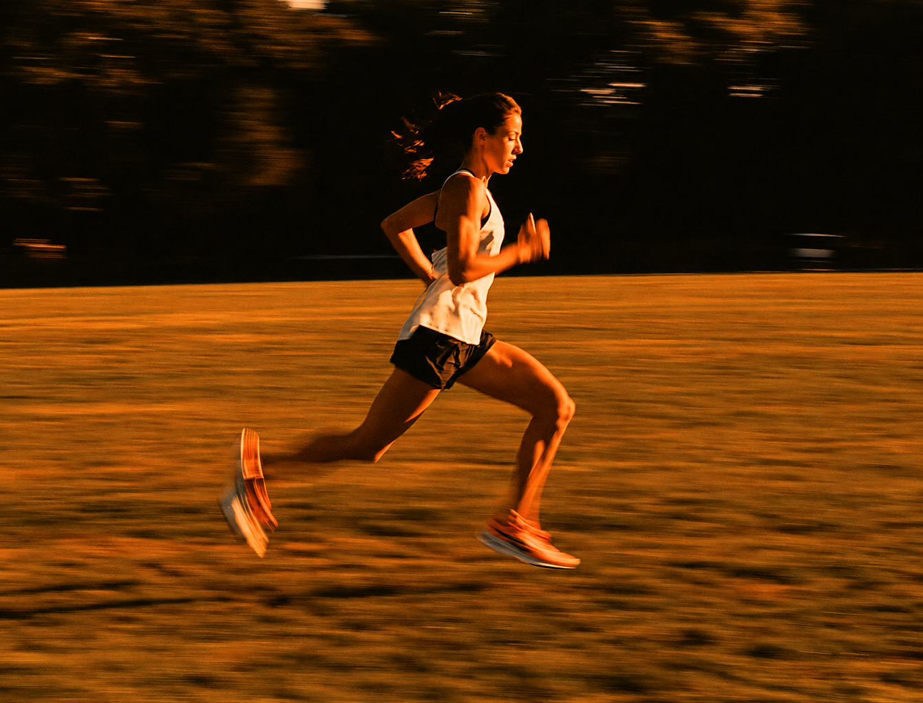 Runner on grass at an easy pace, early light, no strain on the face